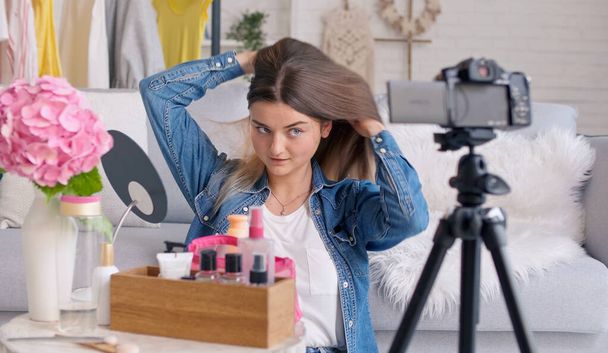 An Attractive Teenage Girl with Her Cute Dog Vlogs While Doing Makeup. A Young Girl Conducts Distance Learning in Makeup, Skin Care, While Blogging. Next Generation of Beauty Influencers - Fotoğraf, Görsel