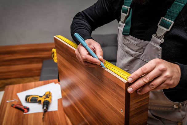 professional furniture maker measures details with a tape measure - Foto, imagen
