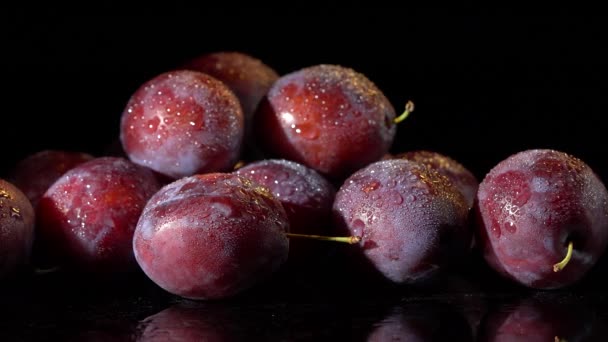 Plums with water drops on black background - Footage, Video