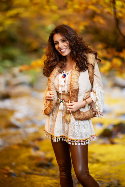 Autumn portrait with a beautiful woman in different positions near a mountain river in the autumn season. - Zdjęcie, obraz