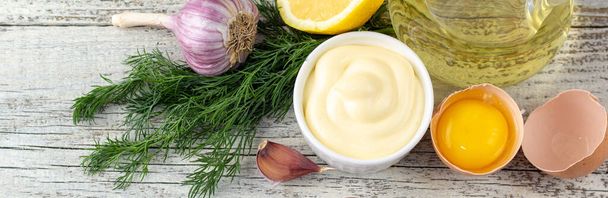 pancarta de salsa de mayonesa con ajo, huevo, aceite, limón y hierbas sobre fondo de madera blanca - Foto, imagen