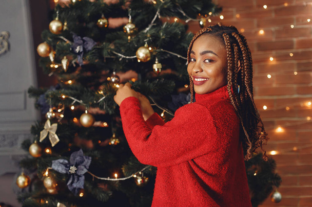 Mixed race girl near Christmas tree at home - Photo, Image