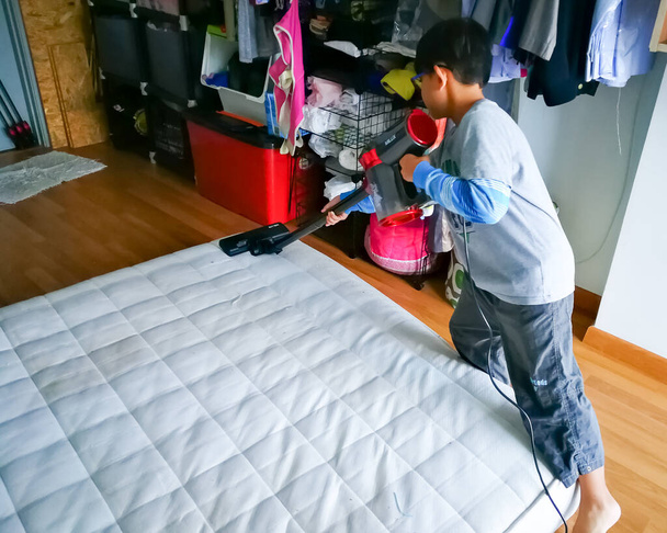 Kuala Lumpur, Malajzia - 2019. november 14.: A matrac tisztítása porszívóval otthon. - Fotó, kép