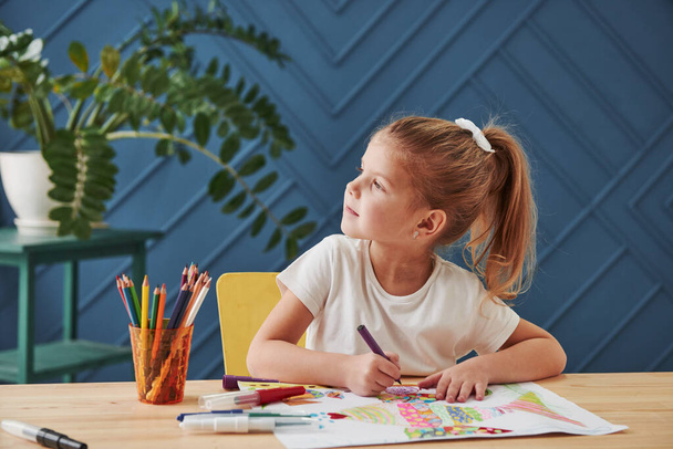 Searching for the ideas. Cute little girl in art school draws her first paintings by pencils and markers. - 写真・画像