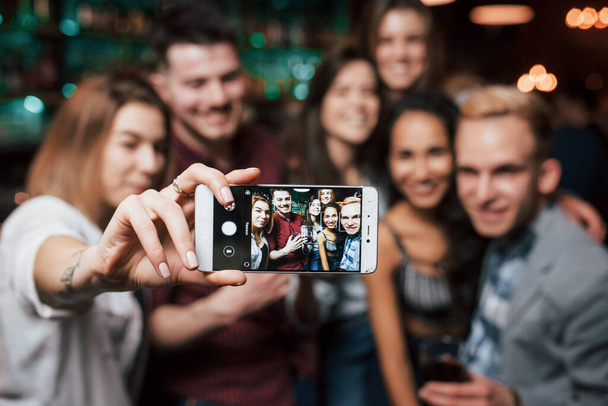 Picture of girl taking photo of herself and her friends at the party. - Valokuva, kuva