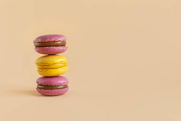 Des macarons français savoureux sur fond jaune pastel. Place pour le texte. - Photo, image