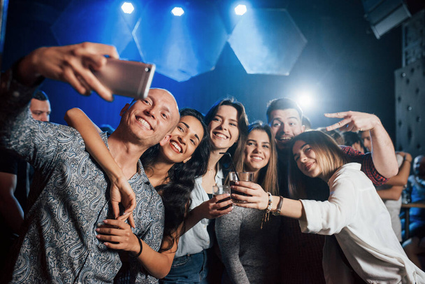 Group of people. Friends taking selfie in beautiful nightclub. With drinks in the hands. - Photo, Image