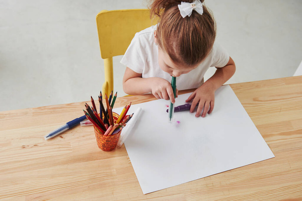Some kind of art techique. Cute little girl in art school draws her first paintings by pencils and markers. - 写真・画像