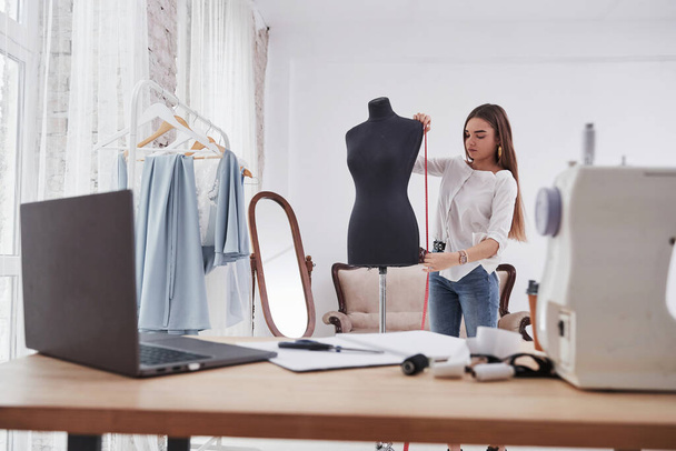 Mannequin height. Female fashion designer works on the new clothes in the workshop. - Φωτογραφία, εικόνα
