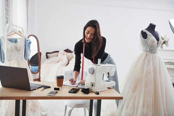 Modern room. Female fashion designer works on the new clothes in the workshop. - Foto, Imagen