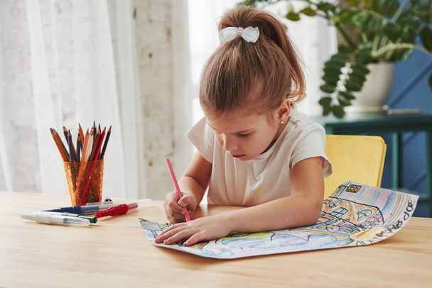 Diligent student. Cute little girl in art school draws her first paintings by pencils and markers. - Fotoğraf, Görsel