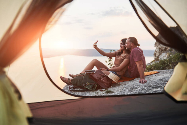 View from tent of couple lying a view of lake during hiking trip. avel Lifestyle concept adventure vacations outdoor. - Φωτογραφία, εικόνα
