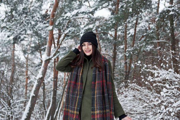 Charming woman. Cheerful young girl in warm clothes have a walk in the winter forest at daytime. - Foto, immagini