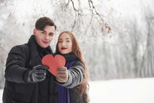 Wishes you love like they have. Gorgeous young couple have good time together in snowy forest. - Foto, imagen