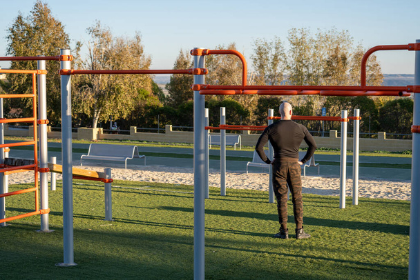 Hombre 7 y atractivo haciendo deporte en las barras en un parque al aire libre - 写真・画像