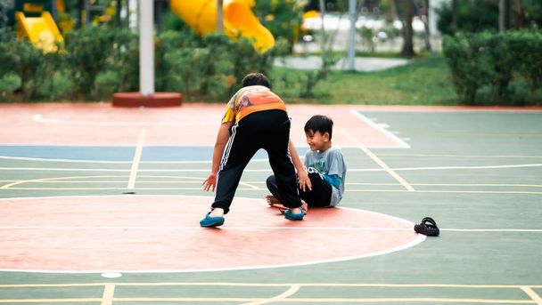 Банги, Малайзия - 10 июля 2019 года: Дети с удовольствием играют на баскетбольной площадке. Дети играют вместе. - Фото, изображение