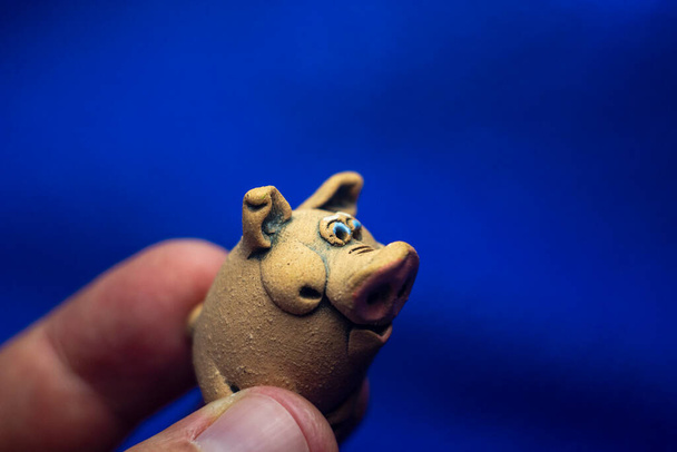 Sculpture of a toy pig on a blue background - Fotó, kép