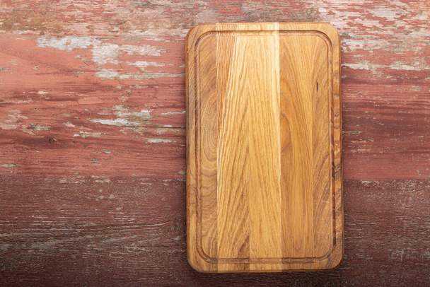 Cutting board on a wooden kitchen table. Space for text. Top view. - Foto, immagini