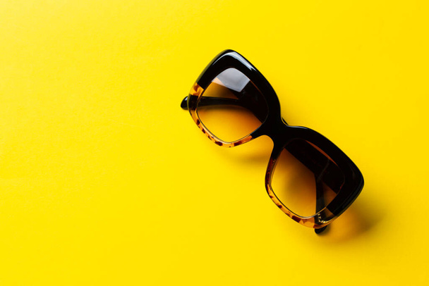 Sunglasses on a yellow background. UV protection. Fashionable accessory. - Zdjęcie, obraz