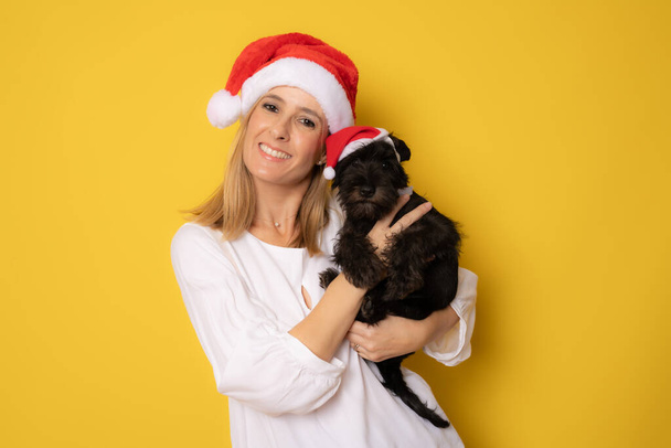 Santa nainen tilalla pieni koira, eristetty keltaisella pohjalla - Valokuva, kuva