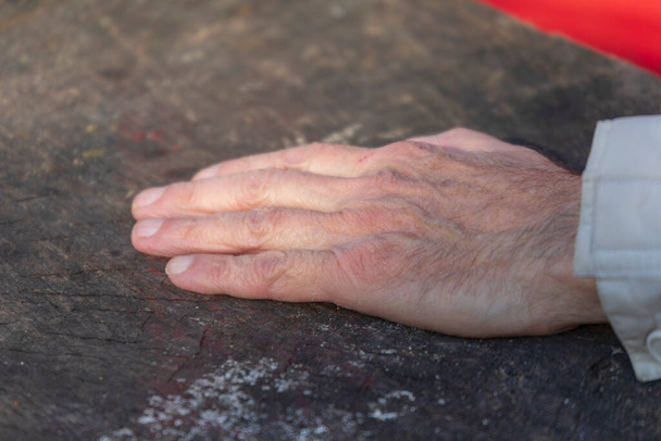 Alter Mann legt Handflächen und Hände auf einen Tisch im Park - Foto, Bild