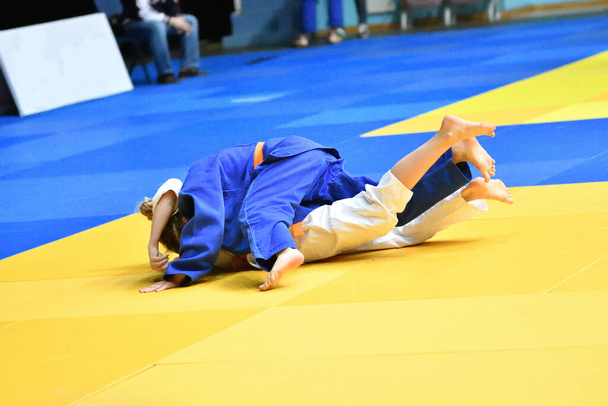 Dwie dziewczyny judoka w kimono rywalizują na tatami  - Zdjęcie, obraz