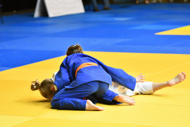 Dos chicas judoka en kimono compiten en el tatami  - Foto, imagen