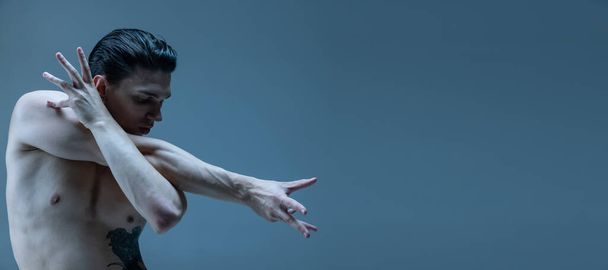 Half-length portrait of young man, flexible male contemp dancer dancing isolated on old navy studio background. Flyer - Foto, Imagem