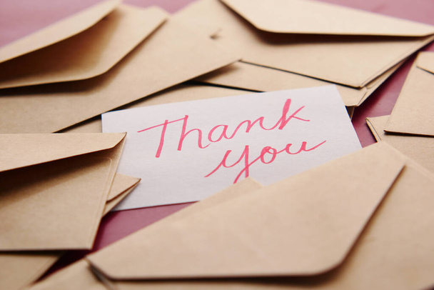 thank you message and envelope on wooden table  - Fotó, kép
