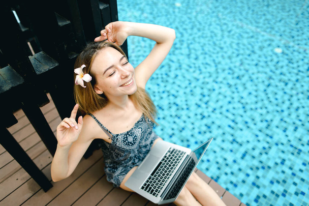 mujer feliz descanso después del trabajo duro en la piscina con el ordenador portátil, d
 - Foto, imagen