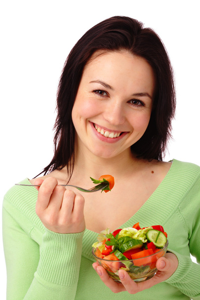 Young attractive woman eats vegetable salad - Foto, afbeelding