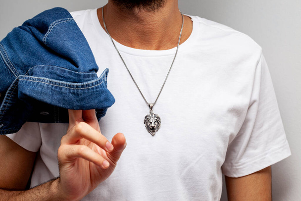 Jonge man model in wit t-shirt poseren met zilveren ketting op zachte achtergrond.voor online winkelen. - Foto, afbeelding
