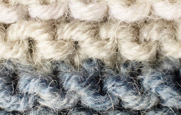 Fondo de punto de color blanco, beige, azul. Textura tejida. Una muestra de tejido de lana. Patrón de punto. patrón de punto de lana. ropa de invierno caliente, bufanda, primer plano. Fondos de pantalla, macro - Foto, Imagen