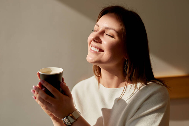 Smiling woman enjoying morning coffee - 写真・画像