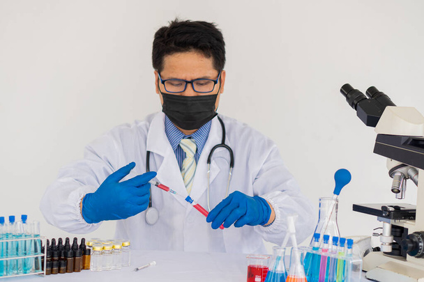 Doctors holding syringes, syringes, and healthcare research workers working in science labs. medical science technology research to test vaccine, vaccine treatment against coronavirus covid-19 - Photo, Image