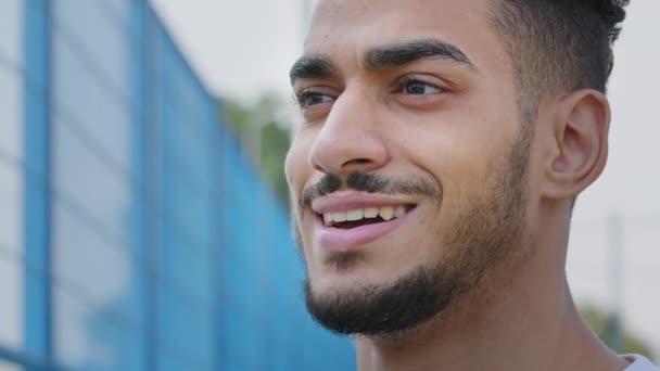 Gelukkige glimlachende jongeman die opzij kijkt, zich verheugt over de ontmoeting, wenkbrauw opheft, vreugde voelt, verrassing, vreugde. Close-up portret Happy millennial Midden-Oosten Indiase man met brede witte tanden glimlach - Video