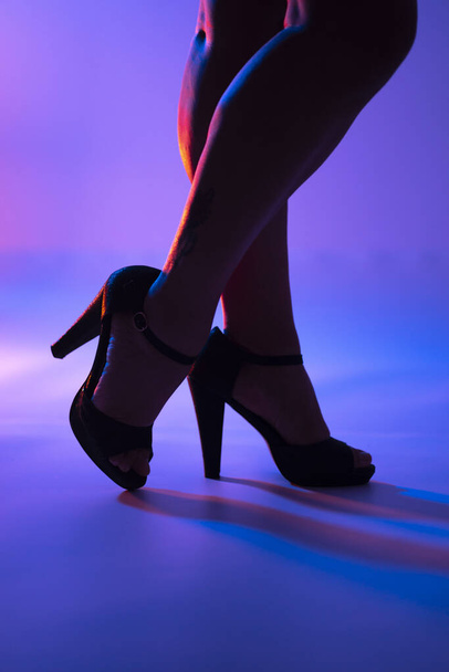 Sexy curvas piernas de señora y zapatos de tacón alto estilete en discoteca luces de baile discoteca. - Foto, imagen