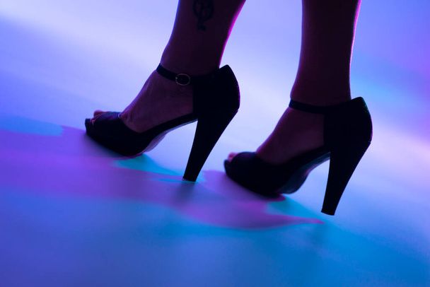 Sexy ronde dame benen en hoge hak stiletto schoenen in disco dance lichten nachtclub. - Foto, afbeelding