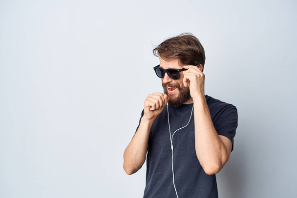 γενειοφόρος άνδρας σε μαύρο t-shirt μουσική σε ακουστικά κίνηση απομονωμένο φόντο - Φωτογραφία, εικόνα