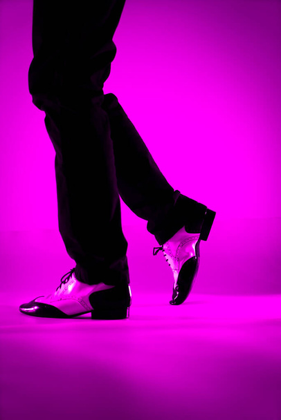 Мужчина танцует в джазовых ботинках из латинского бала с простым цветовым фоном - Фото, изображение