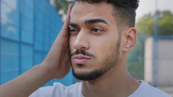 Retrato de close-up triste cansado jovem Oriente Médio árabe homem esfregando templo. Millennial chateado indiana cara estudante toca rosto, quer dormir, sente tensão, dificuldade, dor de cabeça, fadiga ocular, precisa de descanso - Filmagem, Vídeo