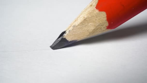 Lápiz de grafito rojo de madera dibuja una línea en un papel blanco - Metraje, vídeo