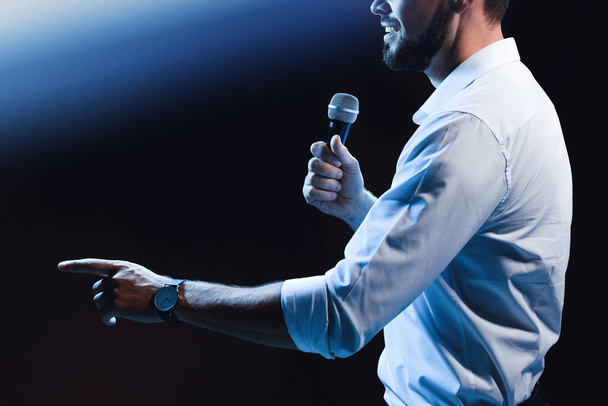 Motivational speaker with microphone performing on stage, closeup - Fotó, kép