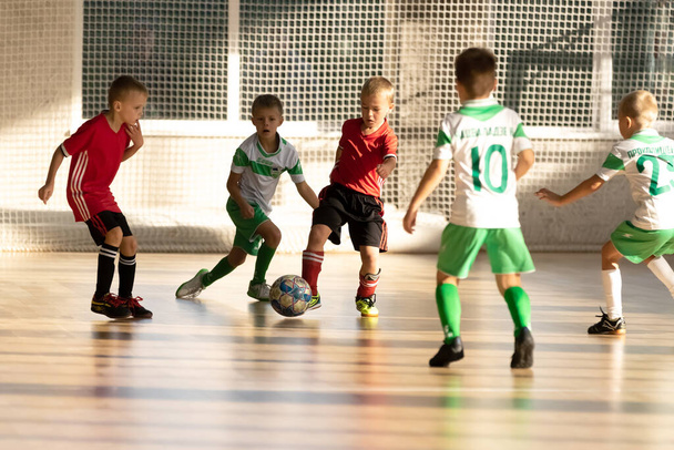 ODESSA, UKRAINE lokakuu 14, 2021: Pikkupojat 8-9 vuotta, lapset pelaavat mini-jalkapallo urheiluhalli klo Ukrainan mestaruus. Lasten urheilu on terveellistä elämäntapaa. Poika urheilu jalkapalloilijat futsal - Valokuva, kuva