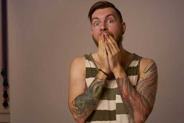 handsome man with tattoos on his arms fashionable hairstyle emotions - 写真・画像