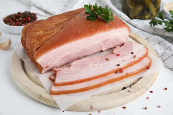 Delicious smoked bacon with parsley and peppercorns on white table - Φωτογραφία, εικόνα