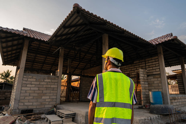 Le contremaître inspecte la construction d'une maison sur le chantier dans le projet de logement - Photo, image
