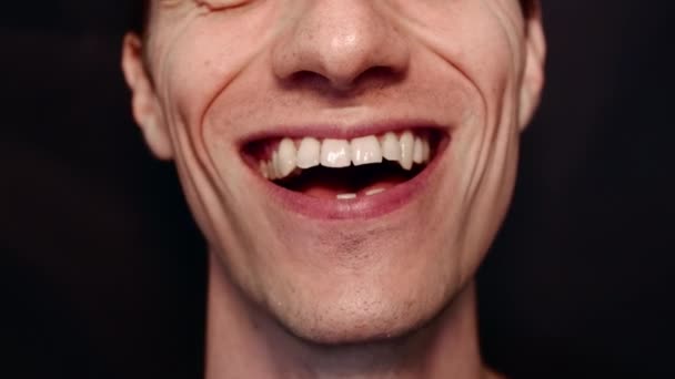 Hombre con dientes grandes y arrugas. Se retuerce, muestra la lengua, sonríe y canta canción - Imágenes, Vídeo