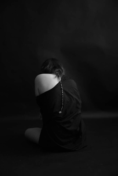 stylish black and white portrait of a girl in strong emotions, closed poses and abstract dark background, soft focus and unfocused photo - Valokuva, kuva