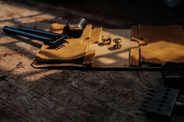 Portefeuille porte-cartes en cuir véritable avec outil sur fond bois artisanat travail - Photo, image